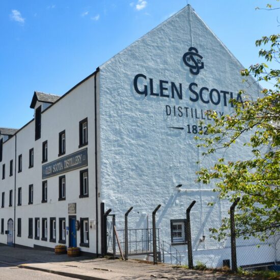 Die Außenaufnahme der Glen Scotia Distillery zeigt das weiße Steingebäude mit für Campbeltown typischen schwarzen Fensterrahmen.