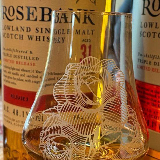 Feines Whisky-Nosingglas mit dem Rosen-Logo der Destillerie vor einer Flasche Rosebank 31 Years.