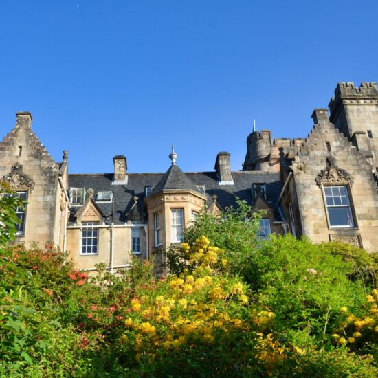 Giebel und Zinnen des Schlosshotels überragen die blühende Azaleen im Schlosspark.